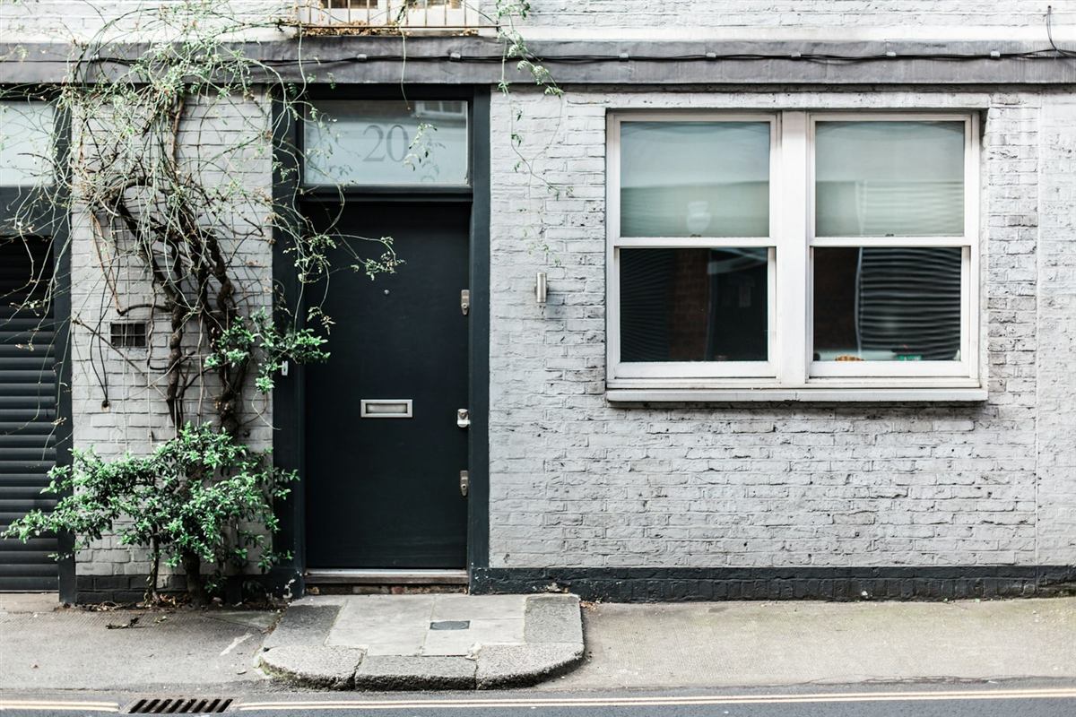 A front door on a white-painted brick terrace